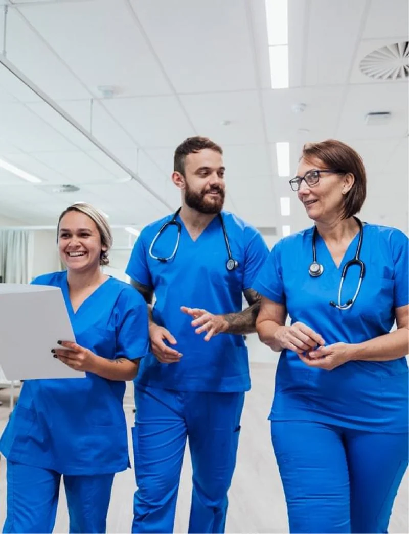 Three nurses walking together in a hospital corridor