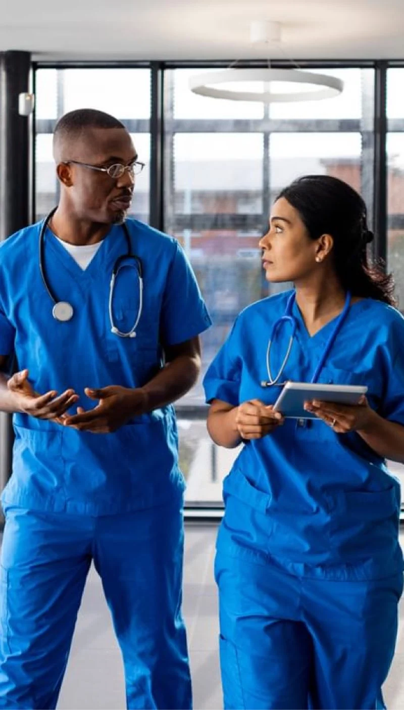 Two nurses talking while walking through a hospital