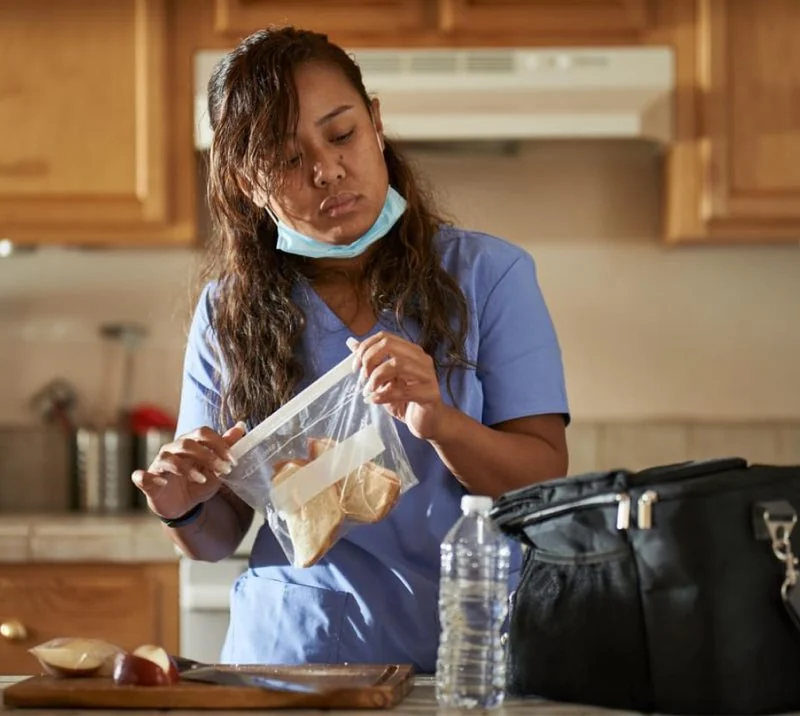 A nurse preparing a meal at home after work